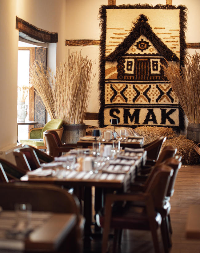 Tisch mit vielen Stühlen und Smak Teppich im Hintergrund